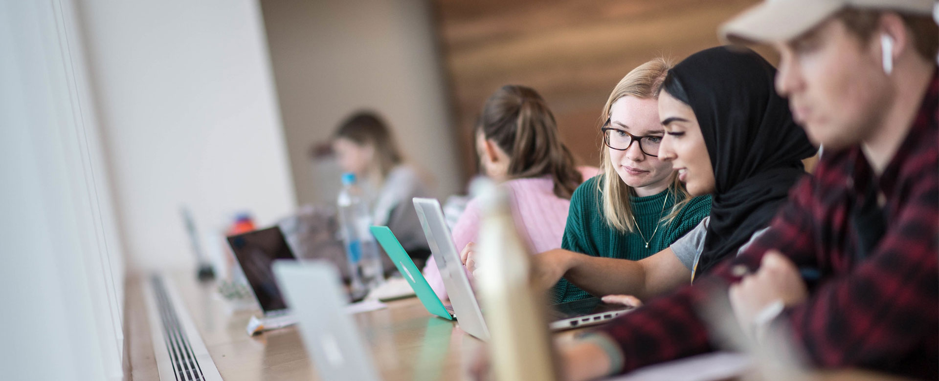 University students looking at laptop