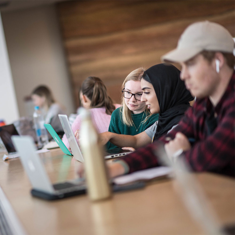 University students looking at laptop